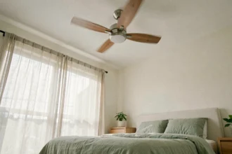 Ventilateur de plafond ultra silencieux au design moderne au-dessus d'un lit douillet dans une chambre paisible